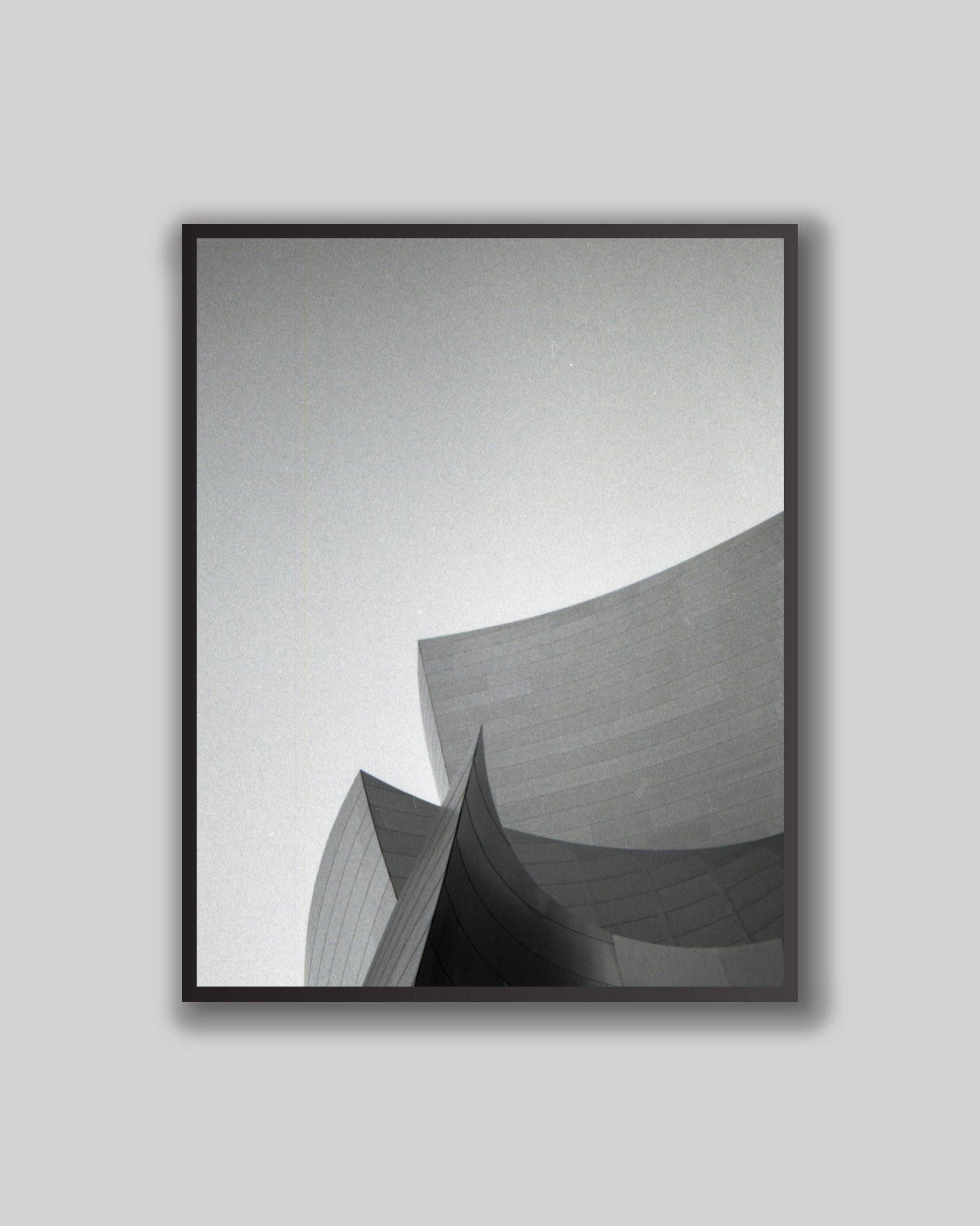 Framed black and white abstract art print on a gray wall