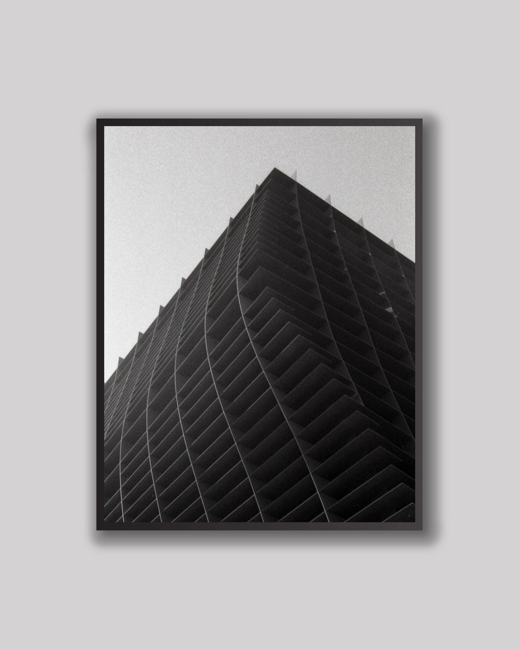Framed black and white architectural artwork on a gray wall