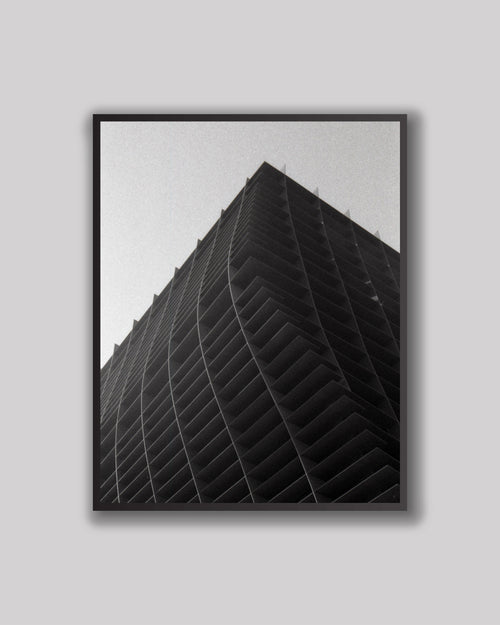 Framed black and white architectural artwork on a gray wall