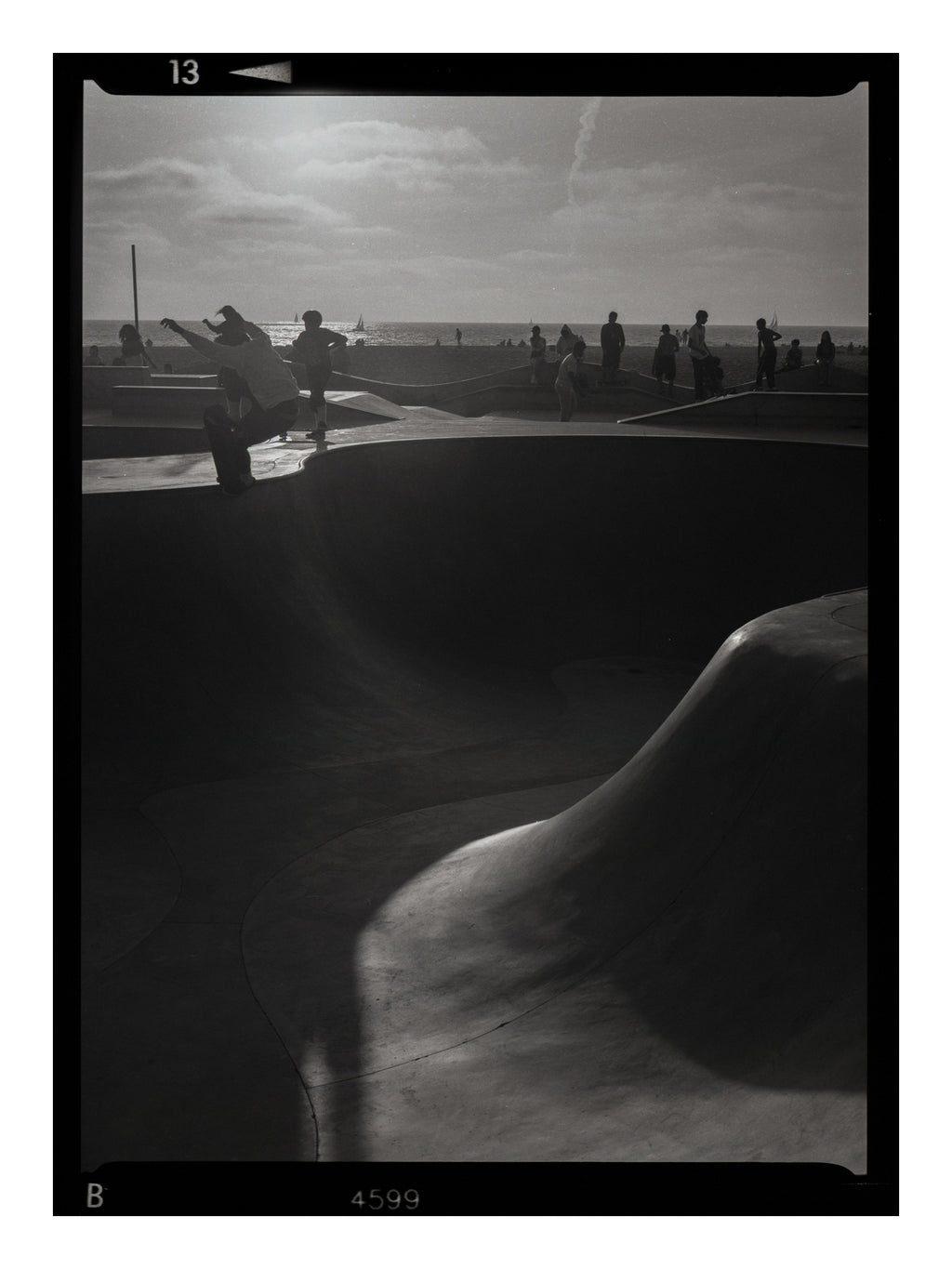 Black and white photograph of a skateboarder at a skate park in Venice Beach California